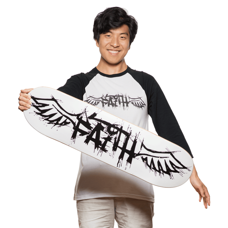 Winged Faith Mellow Skateboard Deck – Front Shot (Male Asian model with mellow skateboard deck in hand)